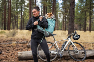 Small dog in a Ruffwear Hitch Hiker Backpack getting put on human's back