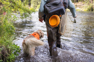 Ruffwear Bivy Bowl in Salamander Orange hanging from the back of a backpack