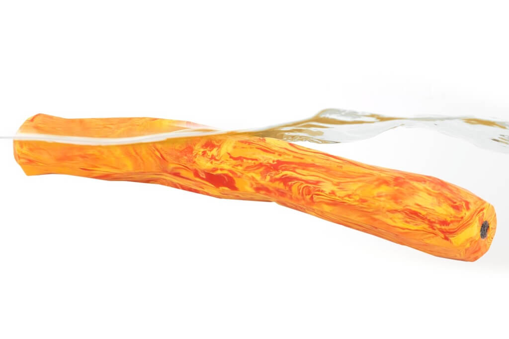 Ruffwear Gnawt-a-Stick Dog Toy in Salamander Orange floating in water.